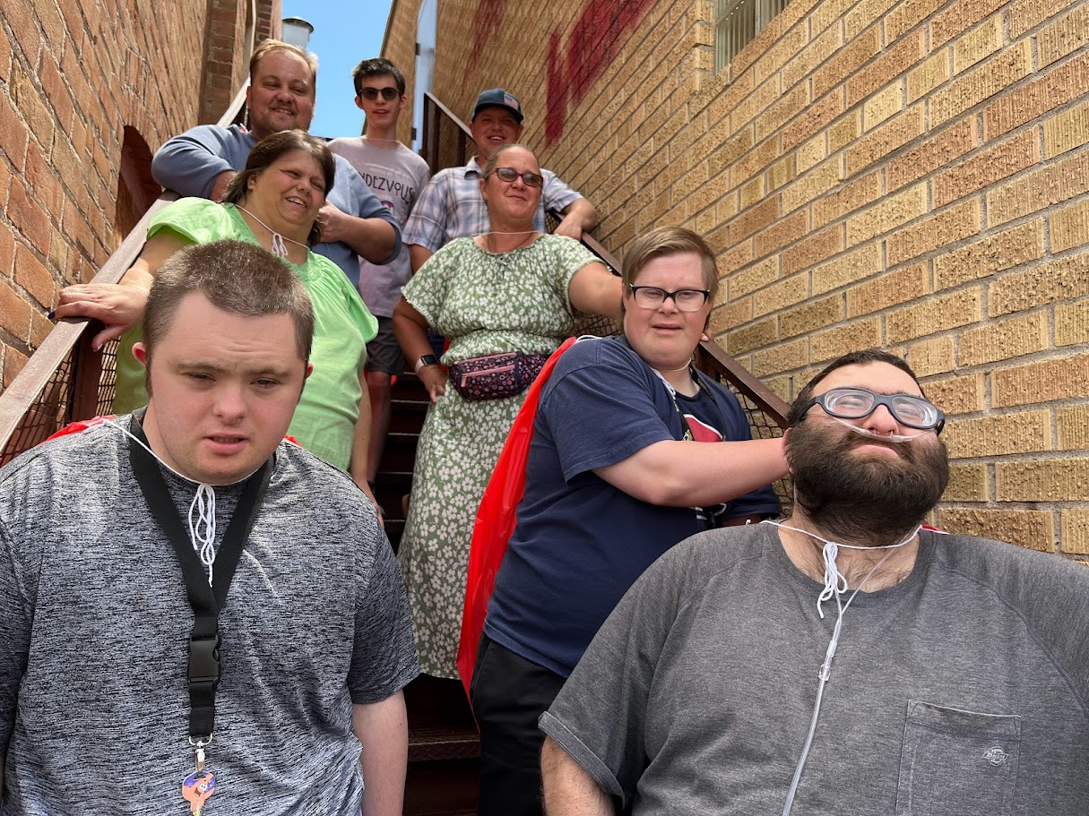 A cheerful gathering of people standing together, posing for a photo in a spacious indoor setting