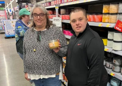 Two individuals in a store showing the scented candle in a glass jar